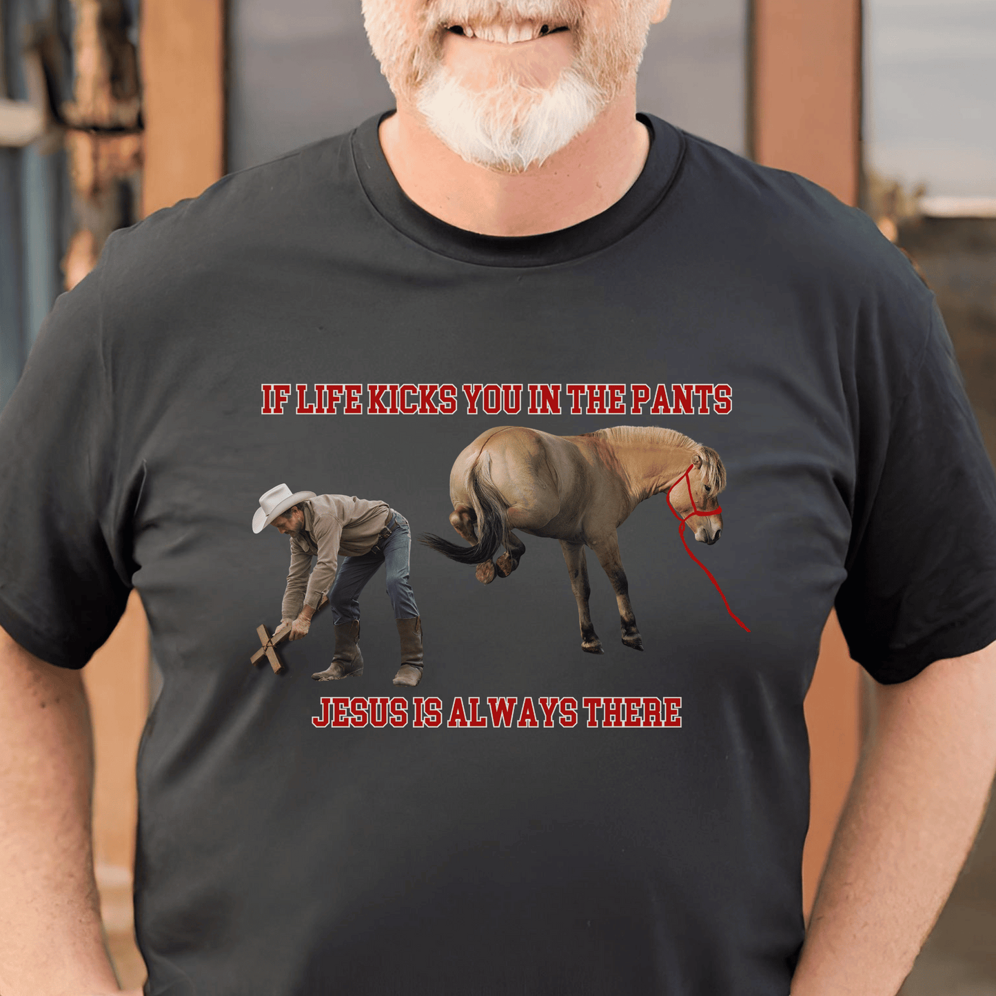 Crew Neck western t-shirt, If Life kicks you in the pants Jesus is always there. with the picture of a cowboy bending over holding a cross getting kicked by a horse.