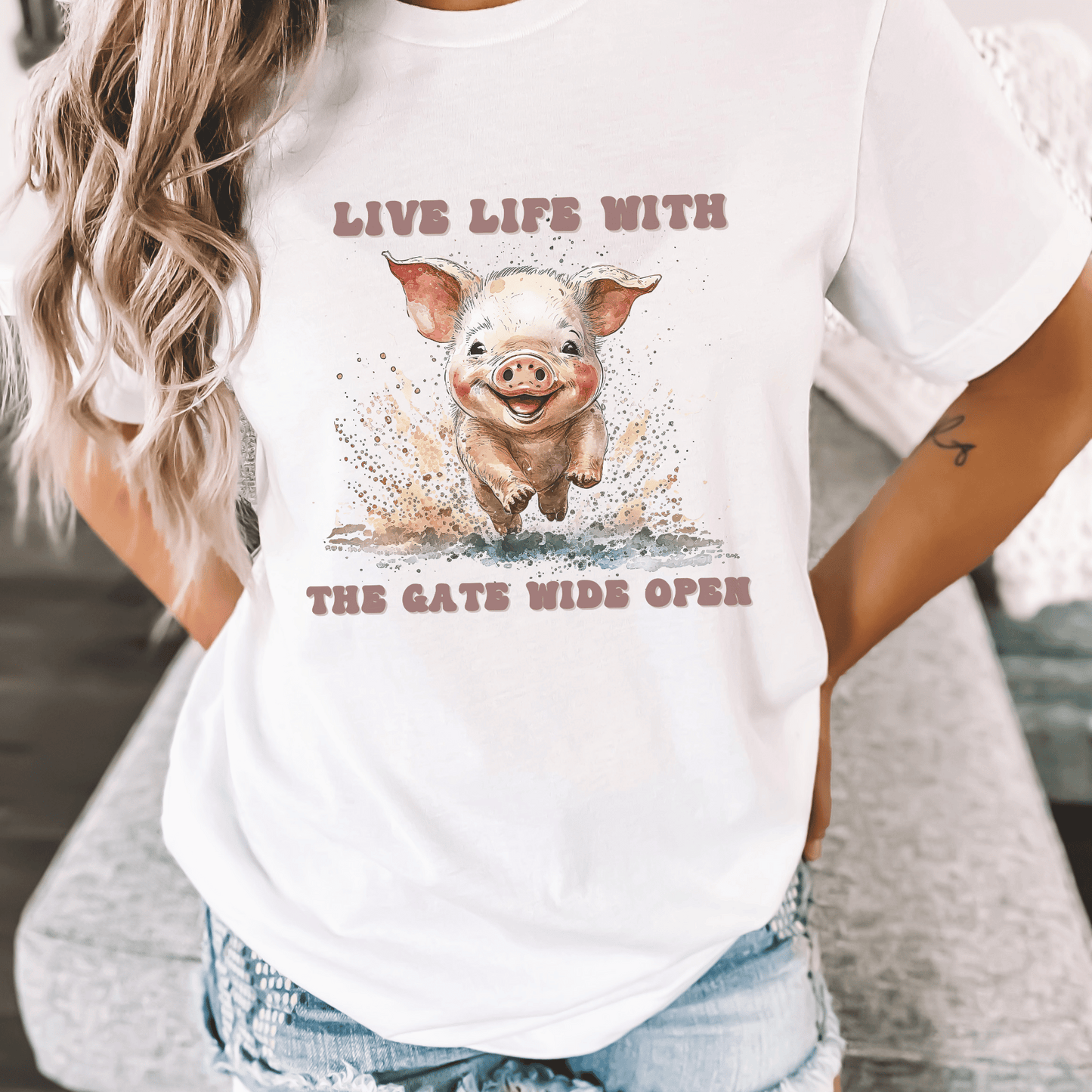 Introducing our Cute Piggy Tee, featuring a charming little pig happily running through the mud. With the inspirational message "Live life with the gate wide open," this farm animal-inspired t-shirt is perfect for anyone who loves country life. Made from high-quality materials, this pink pig shirt is both comfortable and stylish. Order now and show your love for adorable farm animals with our Piggy Shirt!