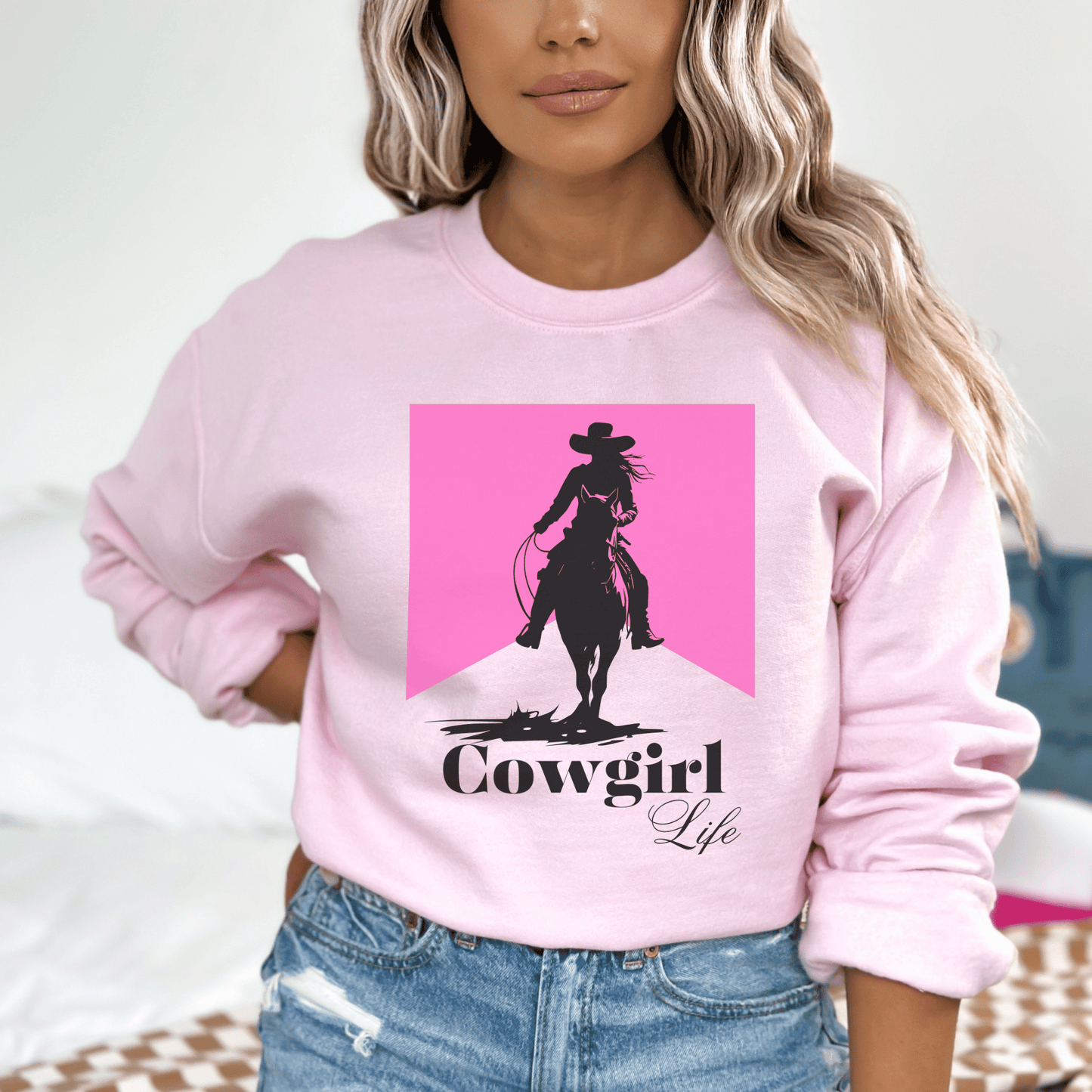 Cowgirl design that says cowgirl Life With a pink background on a crew neck sweatshirt.