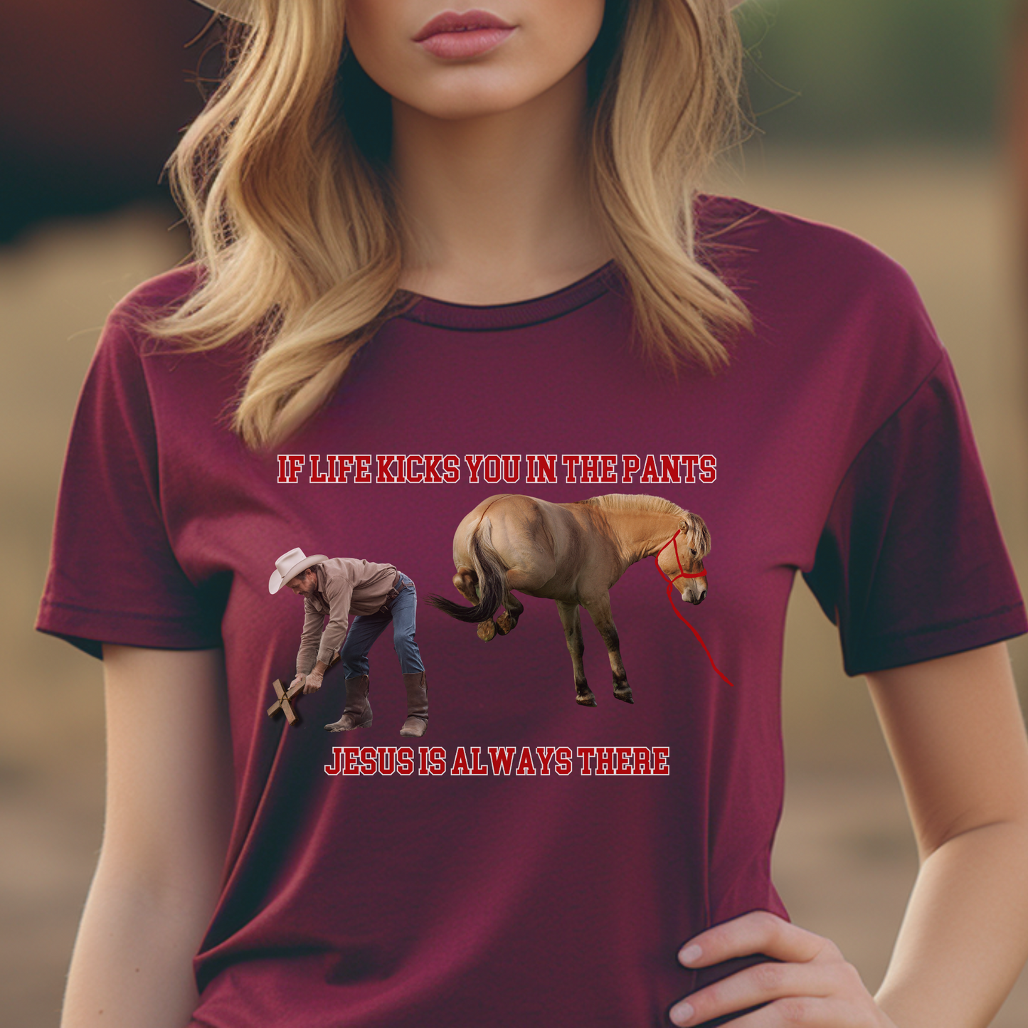 Crew Neck western t-shirt, If Life kicks you in the pants Jesus is always there. with the picture of a cowboy bending over holding a cross getting kicked by a horse.