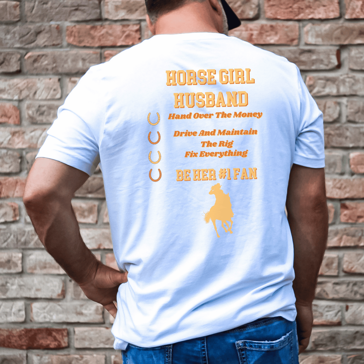 This playful tee showcases the words "Horse Girl Husband" in a stylish font on the back, allowing you to proudly display your role. In addition, the shirt features the phrase "Hand Over the Money, Drive and Maintain the Rig, Fix Everything, and Be Her #1 Fan." This fun and light-hearted design perfectly captures your commitment and love for your wife's passion for horses.