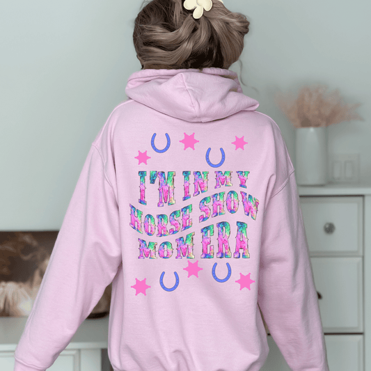 Be stylish while cheering on your equestrian superstar with our Horse Show Mom Era Hoodie. This cozy hoodie features a soft and comfortable fabric that will keep you cozy during those chilly show mornings and evenings.