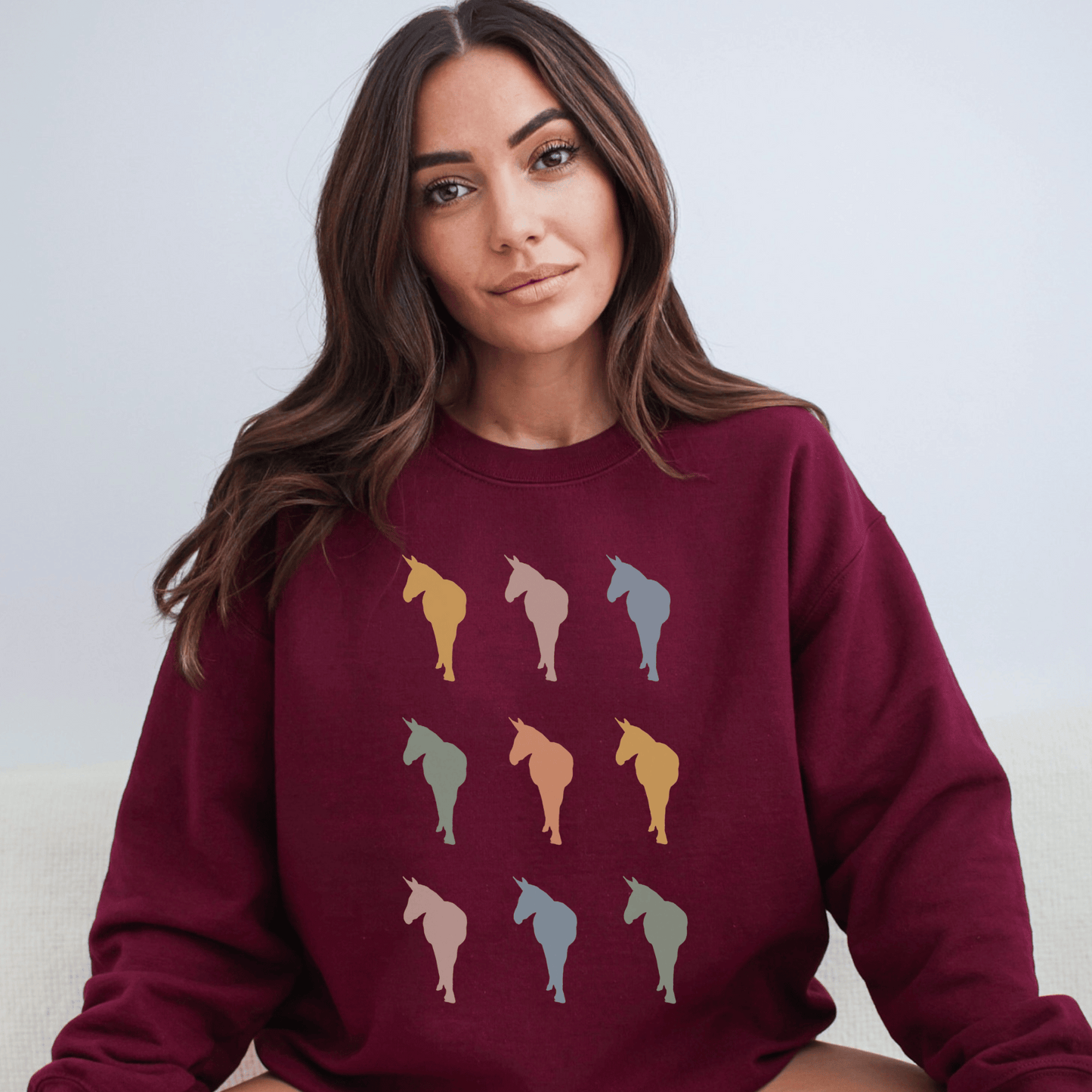 Silhouettes of Donkeys in several vintage colors on a crew neck sweatshirt.