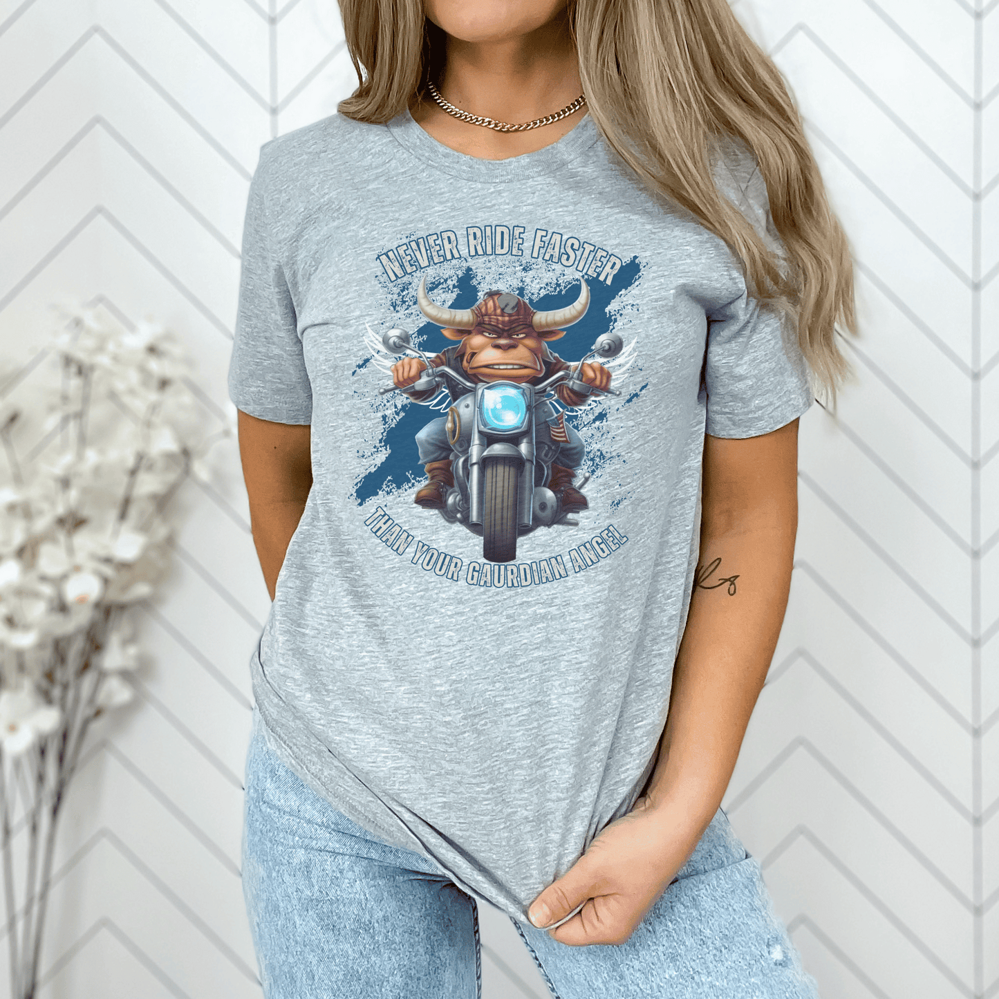 Biker t-shirt with a bull with angel wings riding a motorcyle ,with the saying Never Ride Faster Than Your Gaurdian Angel on a t-shirt.