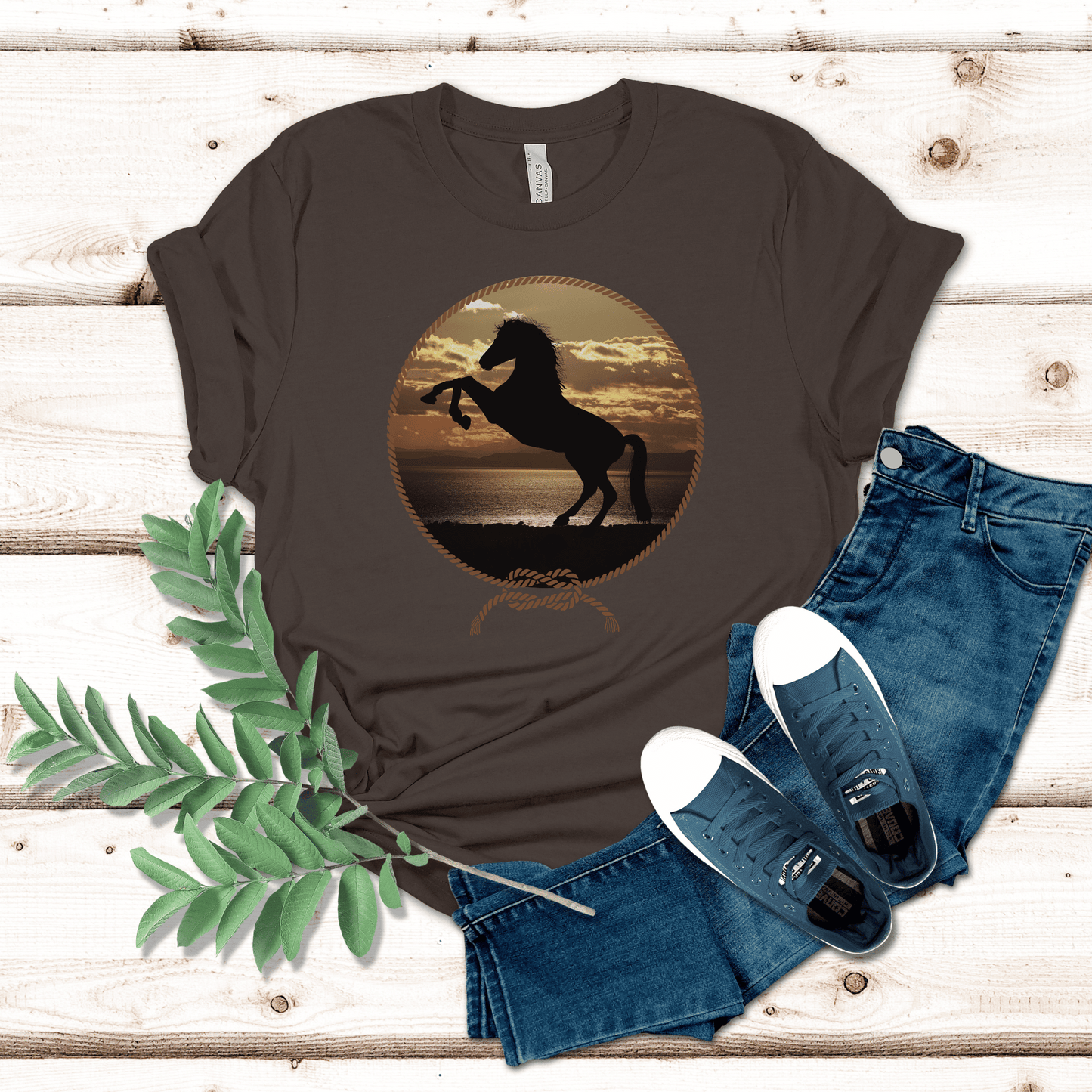 Experience the beauty of the wild west with this Rearing Horse at the Beach tee. Featuring a majestic  rearing horse against a stunning backdrop of sun, sand, and surf at sunset, this unique design brings a bold western vibe to any look. Be the envy of the town!