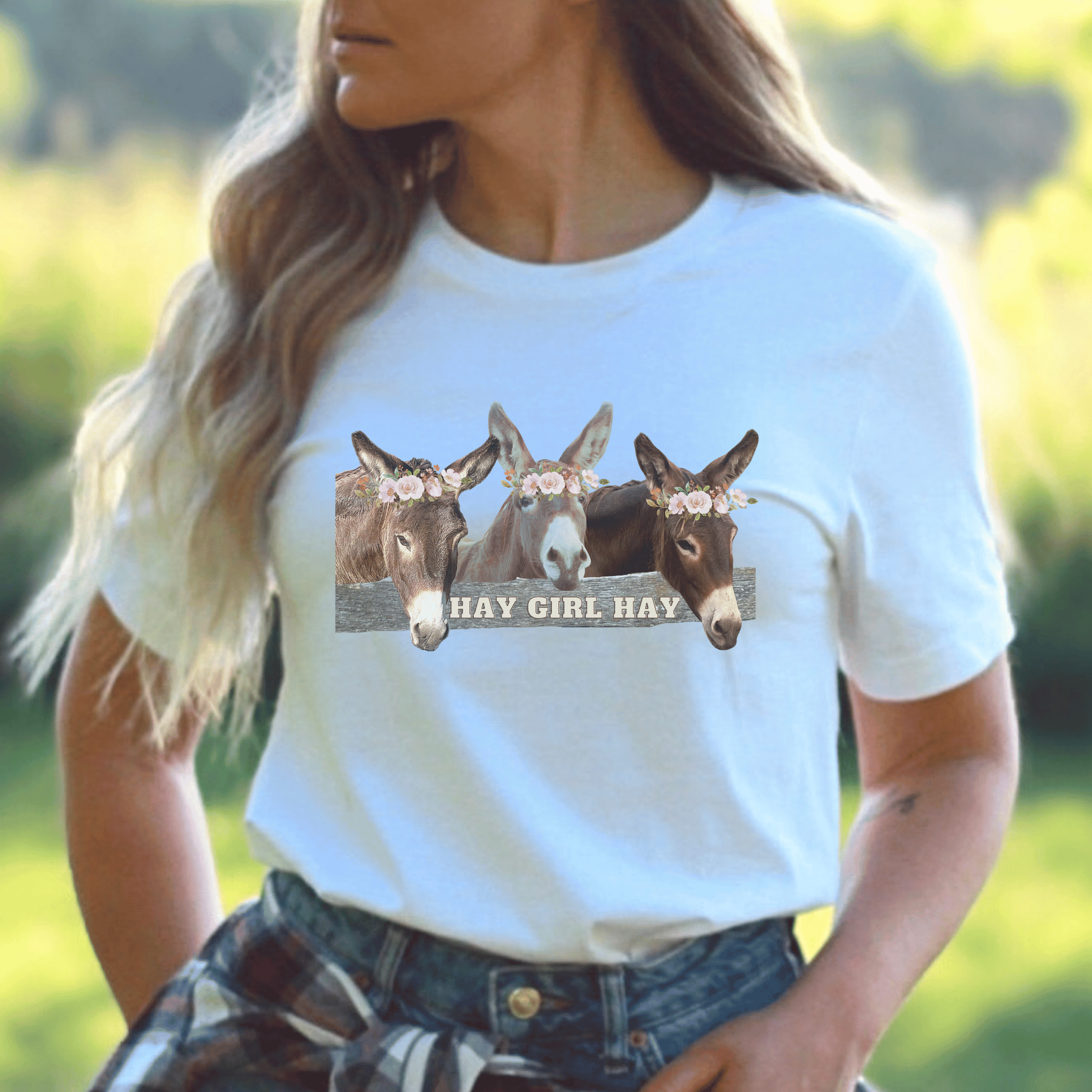 crew neck t-shirt is the perfect gift for any donkey lover! Featuring 3 adorable donkeys peering over a fence and saying "Hay Girl Hay", it's sure to make you smile. The high-quality construction and comfortable fit make it perfect for everyday wear