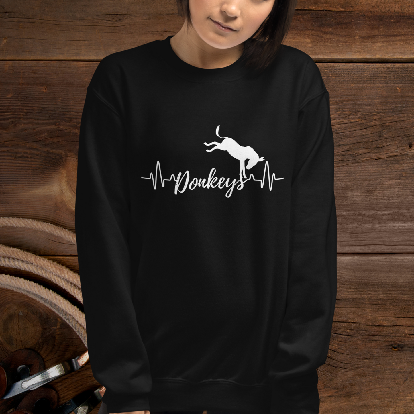 Black crew neck sweatshirt with a heart beat design with  the word Donkeys in the middle of the heartbeat, with a silhouette of a bucking donkey above it.