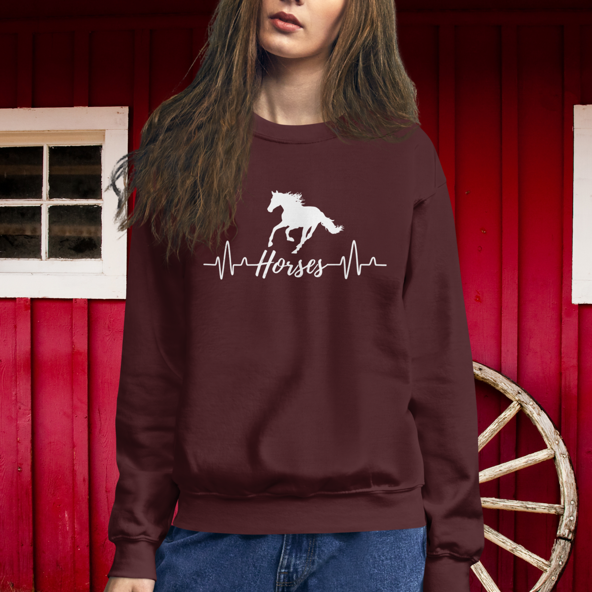 Silhouette of a horse with a heartbeat design with the word horses in the heartbeat .The design is all white printed on a maroon sweatshirt.