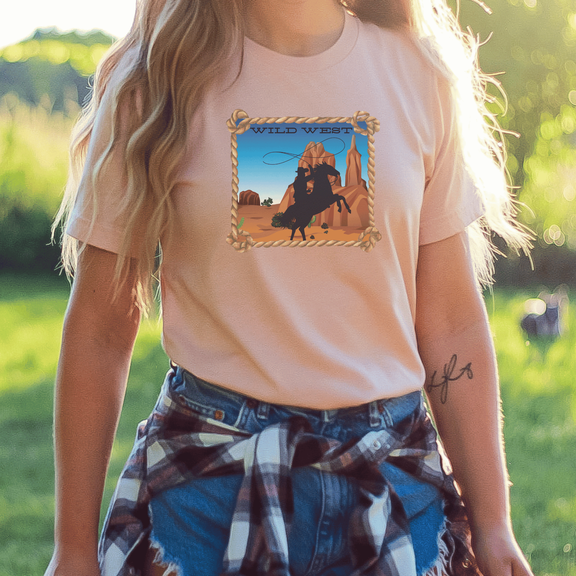 Heather Prism peach colored tee with a wild west desert scene with a rearing horse and cowboy