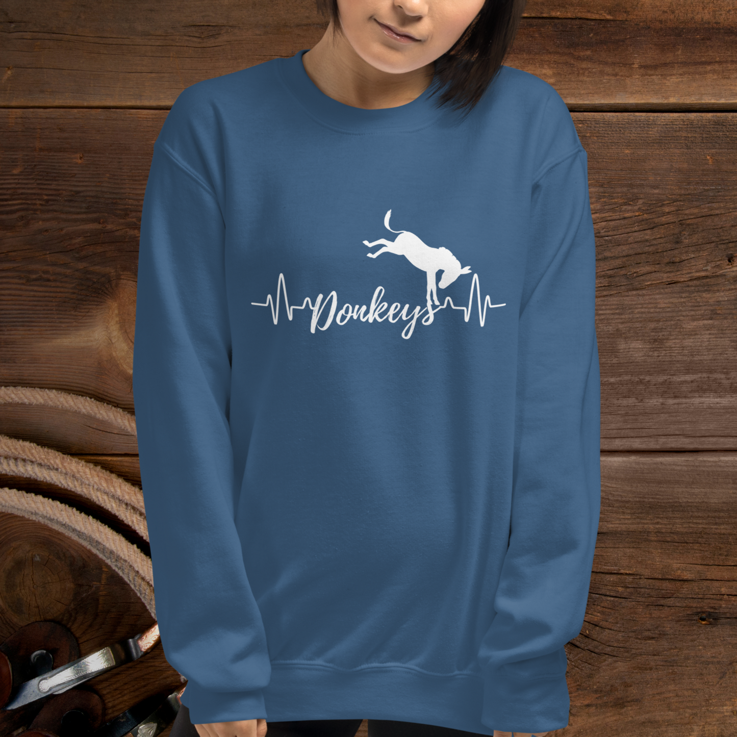 Indigo crew neck sweatshirt with a heart beat design with  the word Donkeys in the middle of the heartbeat, with a silhouette of a bucking donkey above it.