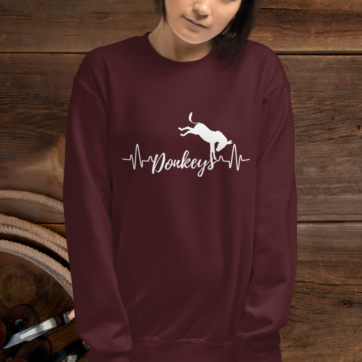 Maroon crew neck sweatshirt with a heart beat design with  the word Donkeys in the middle of the heartbeat, with a silhouette of a bucking donkey above it.