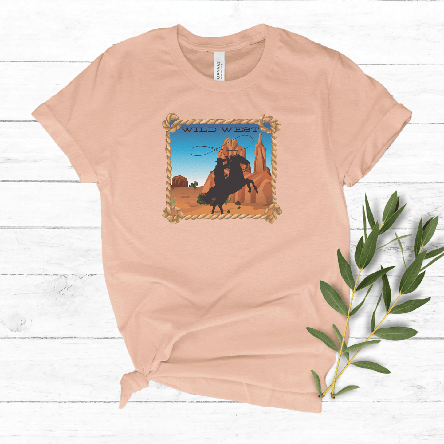 Heather Prism peach colored tee with a wild west desert scene with a rearing horse and cowboy