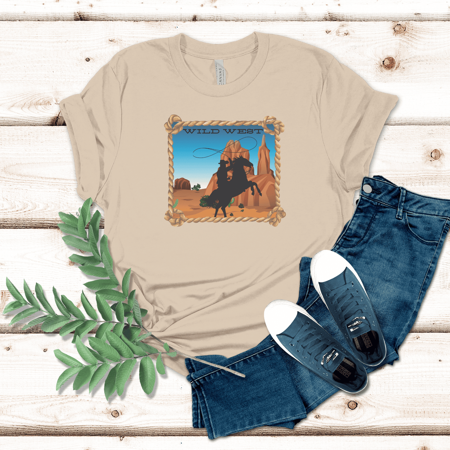 Soft cream colored tee with a wild west desert scene  with a rearing horse and cowboy