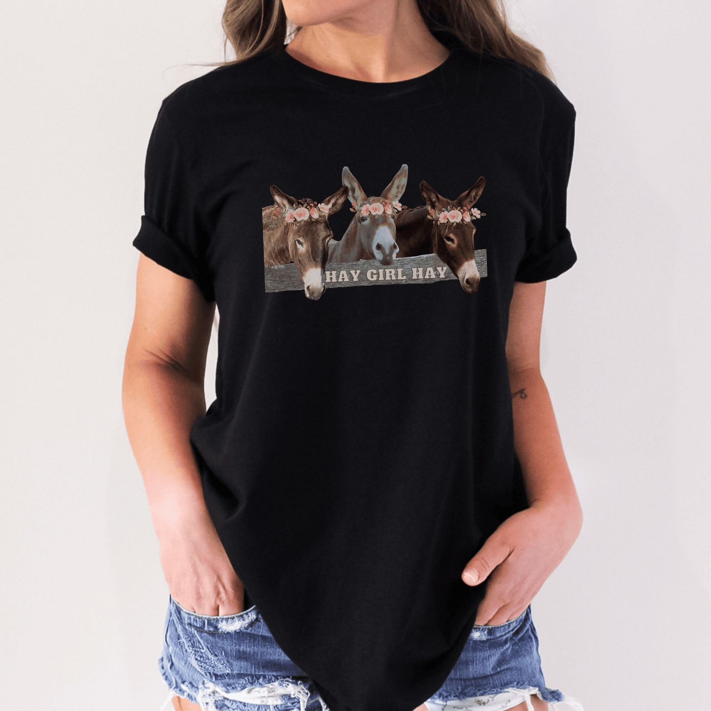 crew neck t-shirt is the perfect gift for any donkey lover! Featuring 3 adorable donkeys peering over a fence and saying "Hay Girl Hay", it's sure to make you smile. The high-quality construction and comfortable fit make it perfect for everyday wear