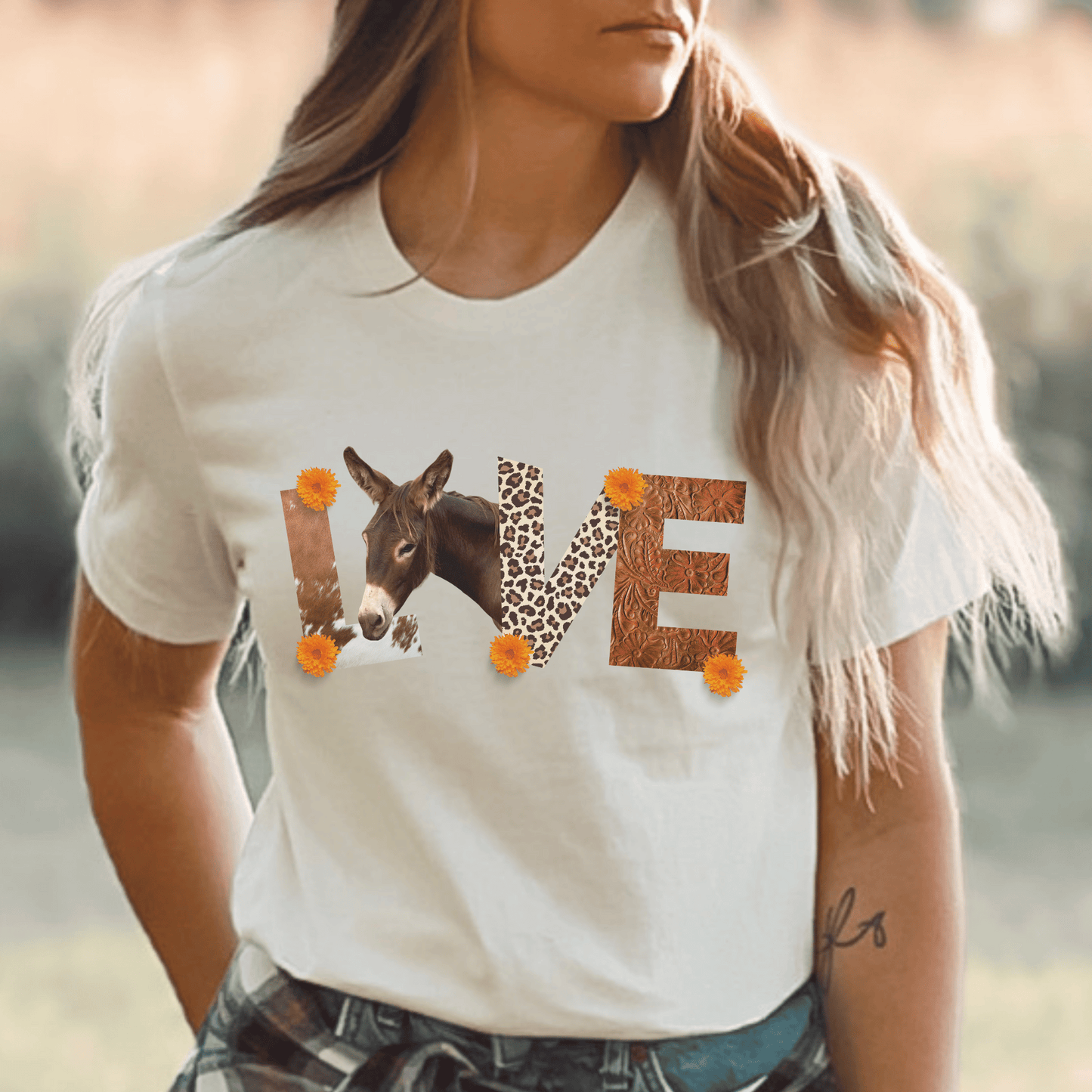 a soft cream tee with leather letters  saying donkey love 